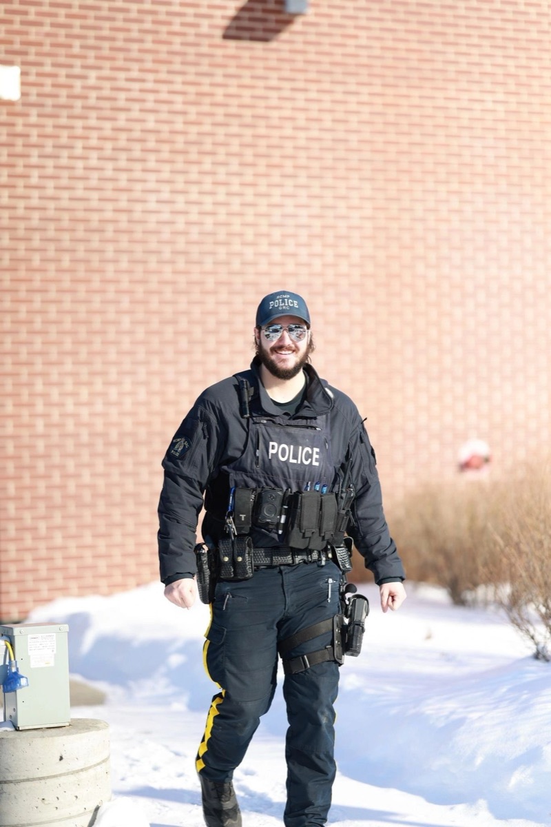 A police officer in uniform walking outside in winter